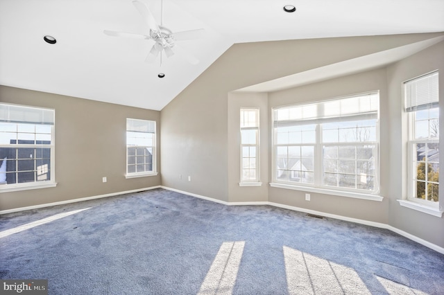 carpeted empty room with vaulted ceiling, ceiling fan, and plenty of natural light