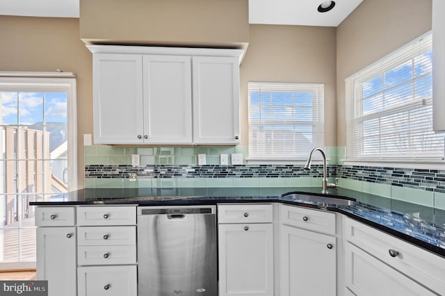 kitchen featuring dark stone counters, dishwasher, sink, and white cabinets