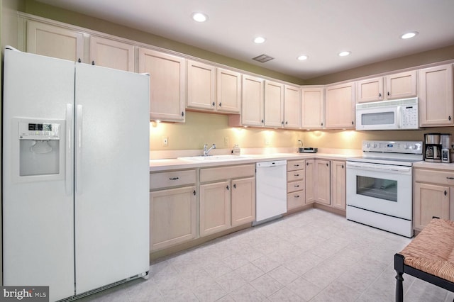 kitchen with white appliances, sink, and light brown cabinets