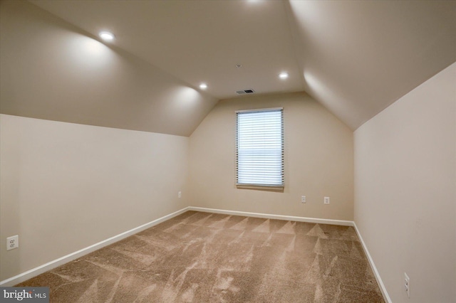 additional living space featuring carpet floors and vaulted ceiling