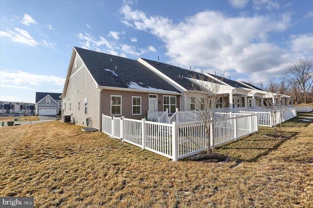 back of house featuring central AC and a lawn