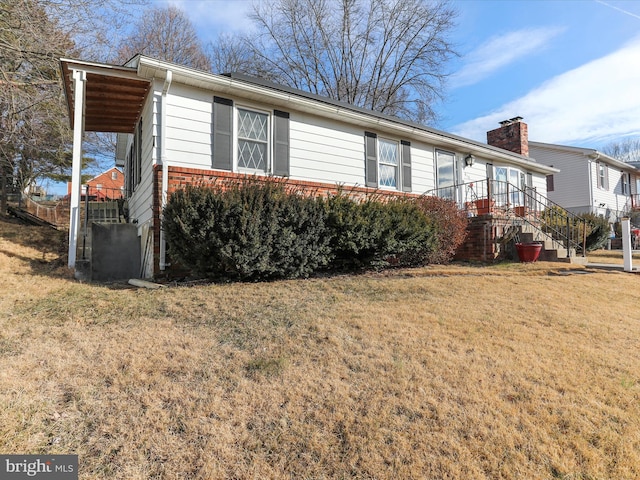 view of property exterior featuring brick siding and a yard