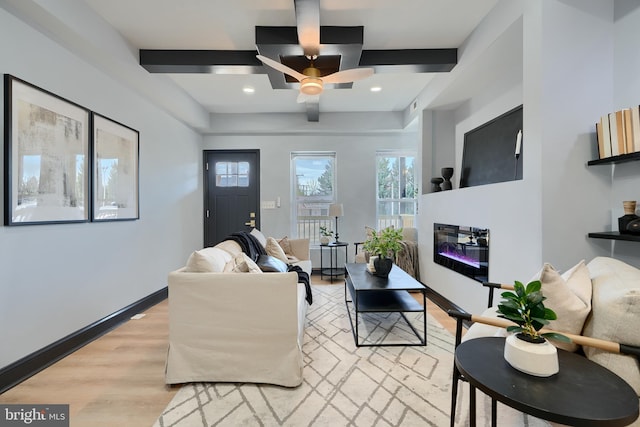 living room with ceiling fan, beam ceiling, and light hardwood / wood-style floors