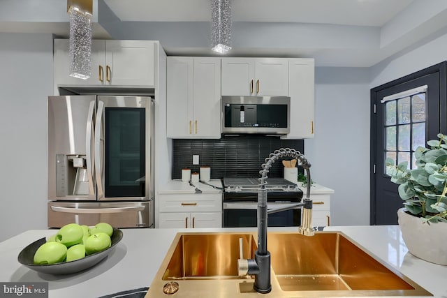 kitchen featuring decorative backsplash, stainless steel appliances, and white cabinets