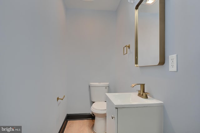 bathroom featuring vanity, hardwood / wood-style flooring, and toilet