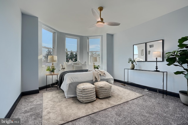 carpeted bedroom featuring multiple windows and ceiling fan