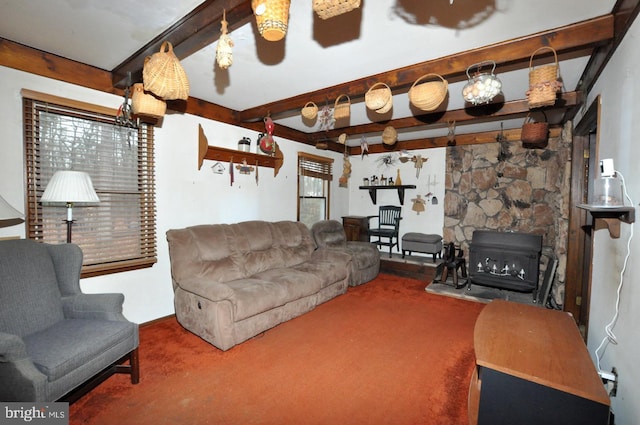 living room with beamed ceiling, ceiling fan, a fireplace, and carpet