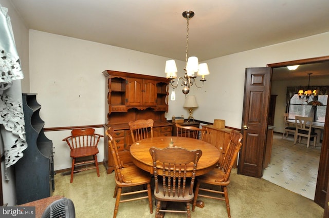 carpeted dining area featuring a notable chandelier