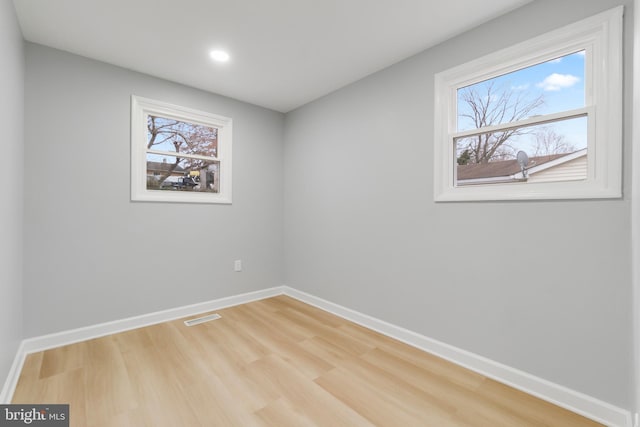 unfurnished room featuring hardwood / wood-style flooring and a healthy amount of sunlight