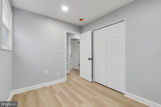 unfurnished bedroom featuring light hardwood / wood-style floors and a closet