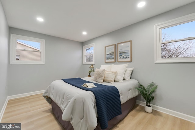 bedroom with multiple windows and light wood-type flooring