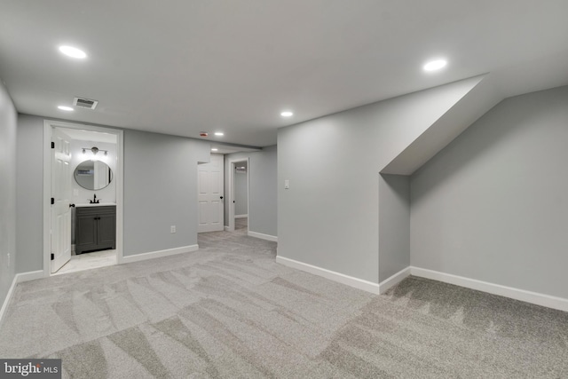 basement with sink and light carpet