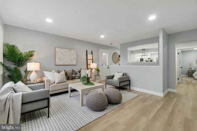 living room with a notable chandelier and light hardwood / wood-style flooring