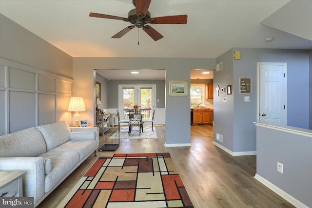 living room featuring sink, hardwood / wood-style flooring, and ceiling fan