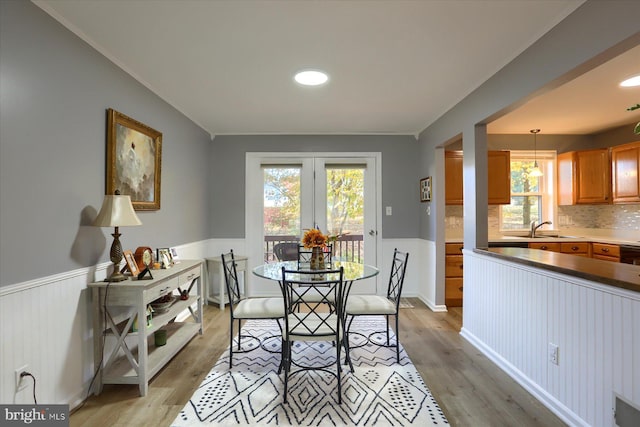 dining space featuring plenty of natural light, sink, and light hardwood / wood-style flooring