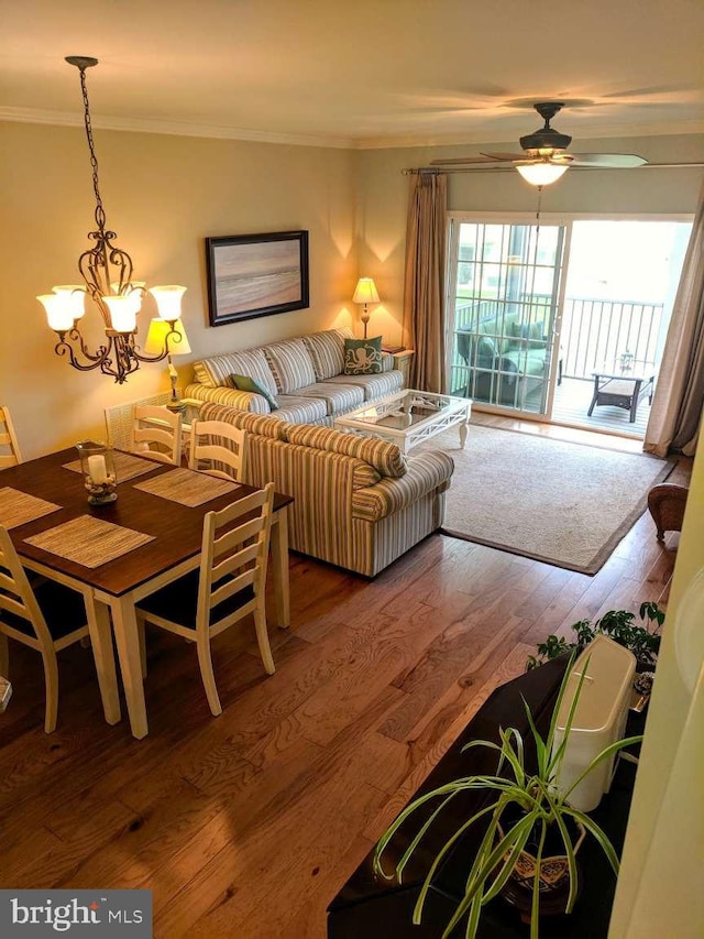 living room with crown molding, ceiling fan with notable chandelier, and hardwood / wood-style floors