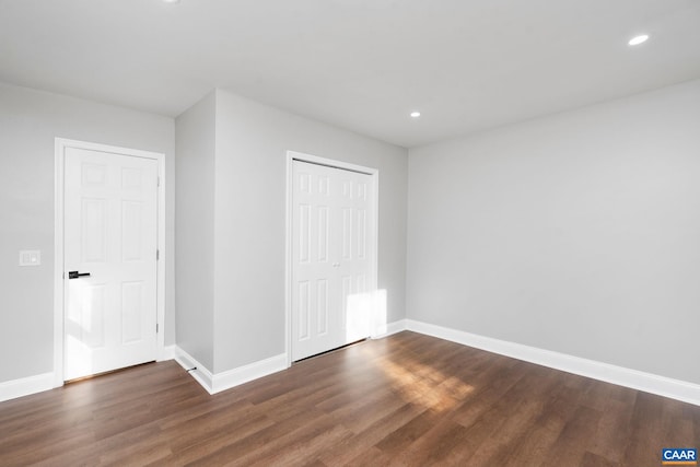 unfurnished bedroom featuring dark wood-type flooring and a closet