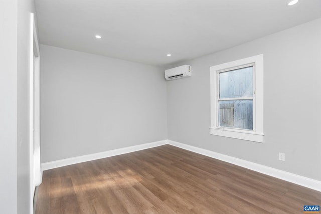 empty room featuring a wall mounted air conditioner and dark wood-type flooring