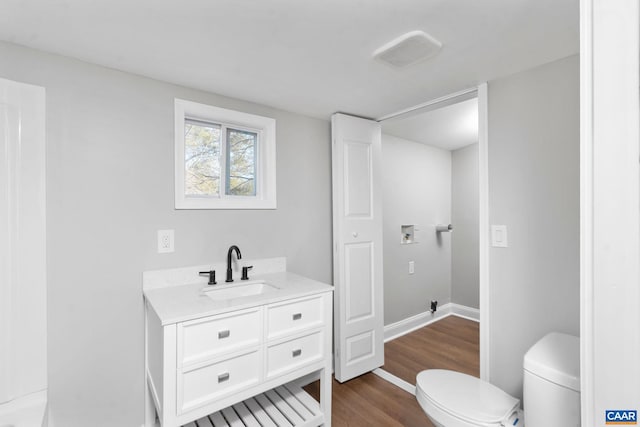 bathroom featuring vanity, wood-type flooring, and toilet