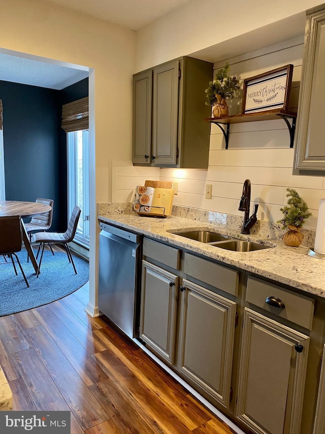 kitchen with gray cabinets, sink, dark hardwood / wood-style flooring, stainless steel dishwasher, and light stone countertops