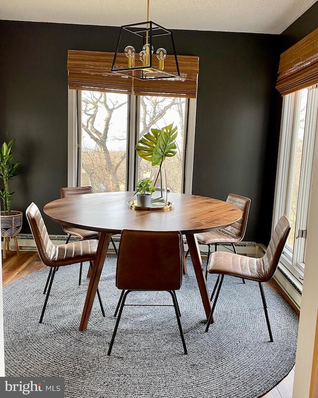 dining space featuring wood-type flooring and a notable chandelier