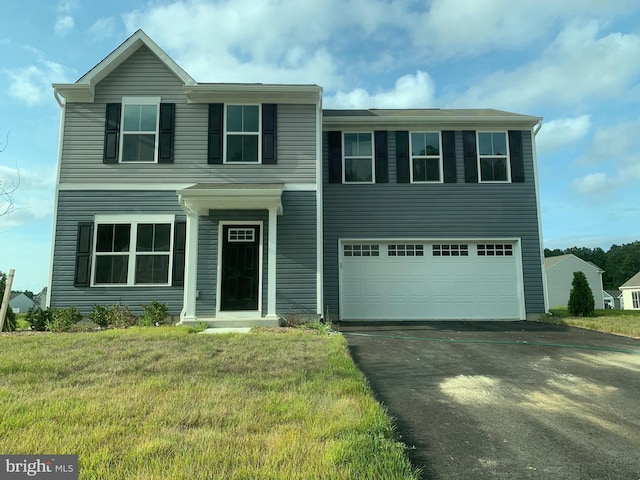 view of front of property with a garage, a front yard, and driveway