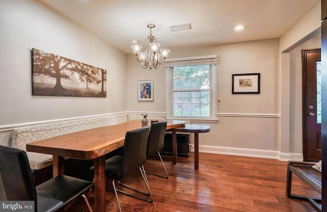 dining space featuring wood-type flooring and a notable chandelier