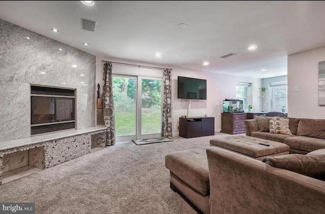 carpeted living room featuring a high end fireplace