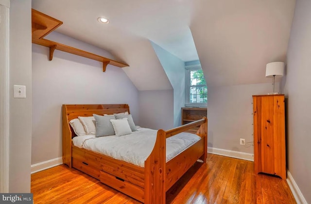 bedroom featuring vaulted ceiling and hardwood / wood-style floors