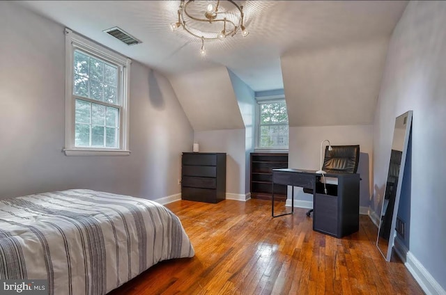 bedroom with lofted ceiling and wood-type flooring