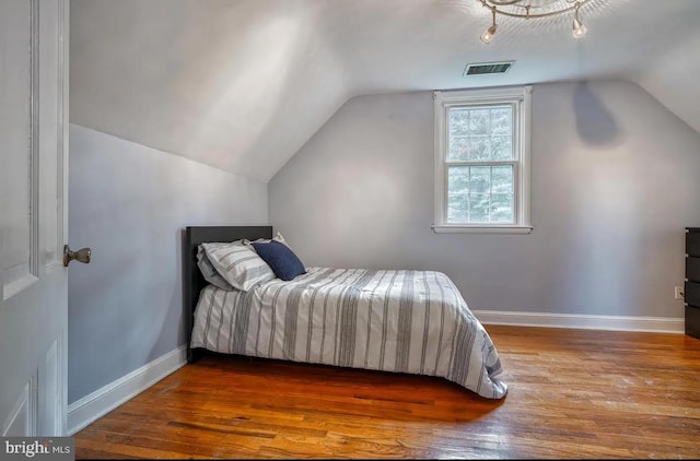 bedroom with hardwood / wood-style flooring and vaulted ceiling