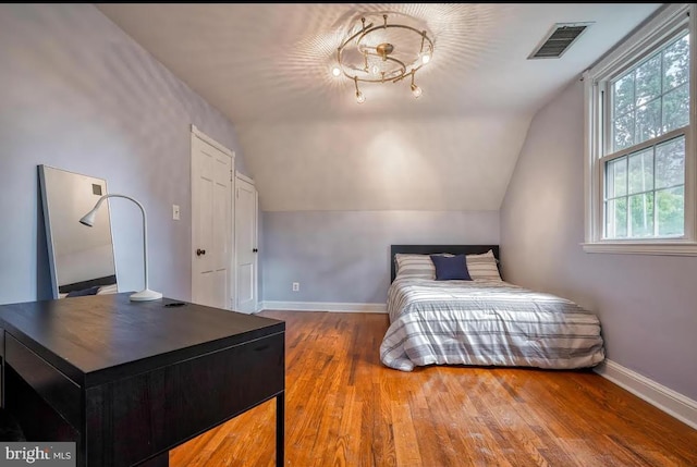 bedroom featuring hardwood / wood-style flooring and vaulted ceiling