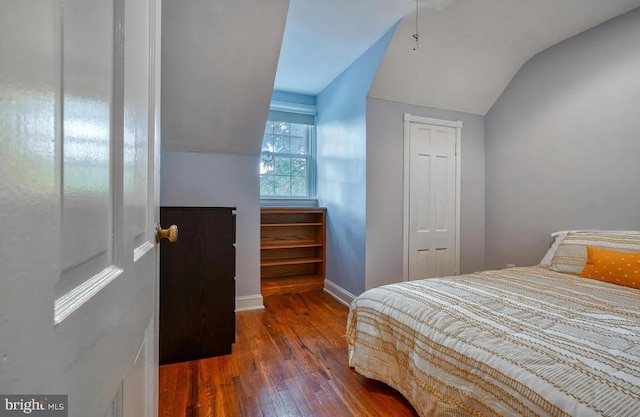 bedroom with dark hardwood / wood-style flooring and vaulted ceiling