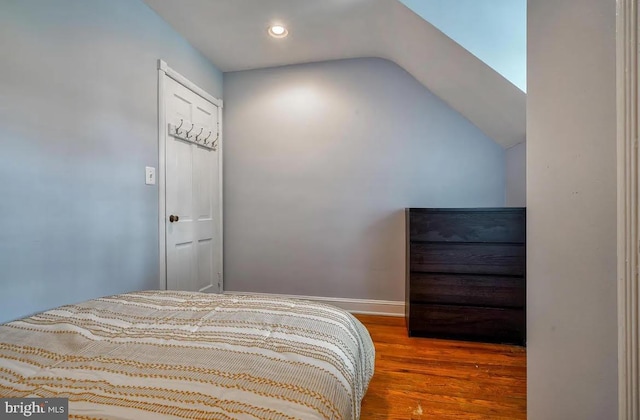 bedroom featuring hardwood / wood-style flooring and vaulted ceiling