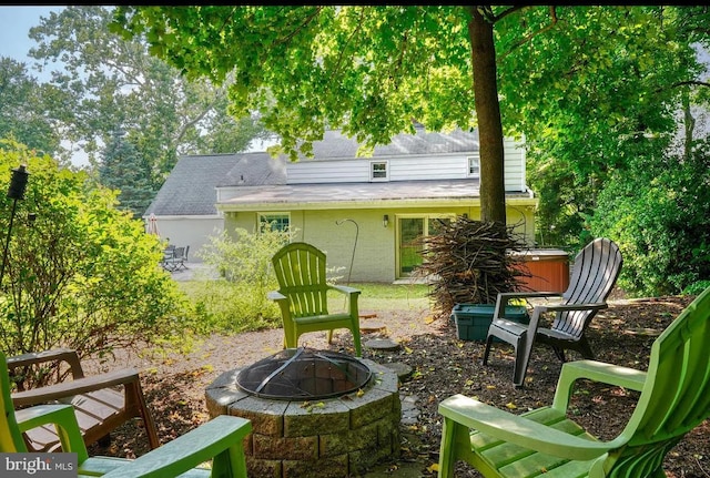 view of patio / terrace featuring a hot tub and a fire pit