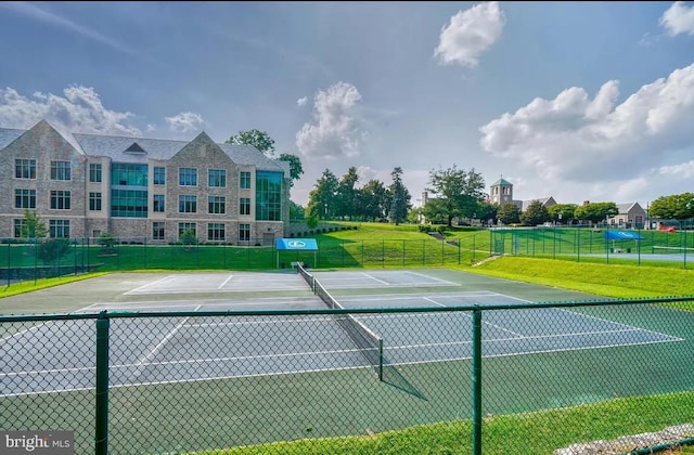 view of tennis court featuring a yard