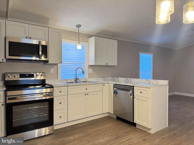 kitchen with pendant lighting, sink, appliances with stainless steel finishes, white cabinets, and kitchen peninsula