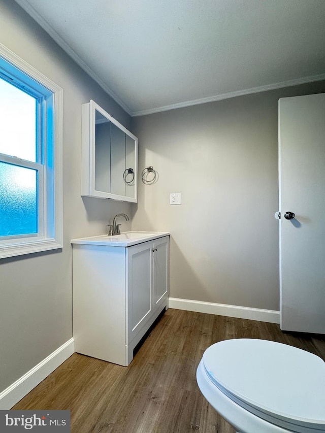 bathroom with crown molding, vanity, toilet, and hardwood / wood-style floors