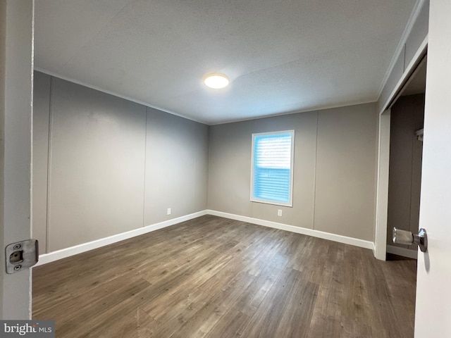 unfurnished bedroom featuring crown molding and dark hardwood / wood-style flooring