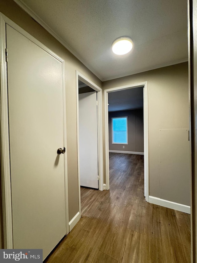 corridor with wood-type flooring and a textured ceiling