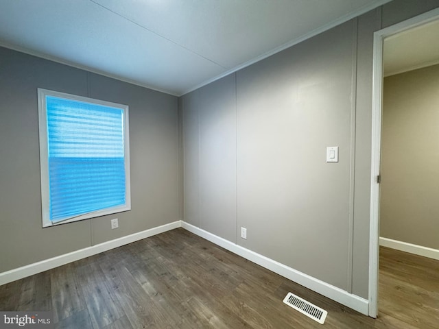 spare room featuring hardwood / wood-style flooring and crown molding