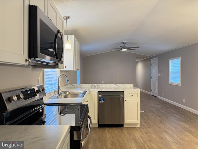 kitchen with stainless steel appliances, white cabinetry, pendant lighting, and light wood-type flooring