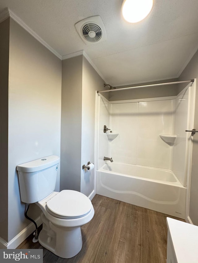 full bathroom with shower / bathing tub combination, hardwood / wood-style flooring, ornamental molding, vanity, and toilet