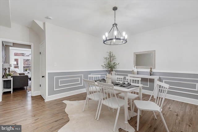 dining room featuring hardwood / wood-style floors and an inviting chandelier