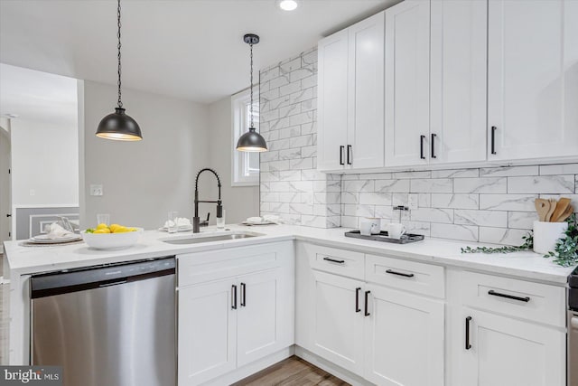 kitchen with sink, dishwasher, white cabinetry, hanging light fixtures, and decorative backsplash