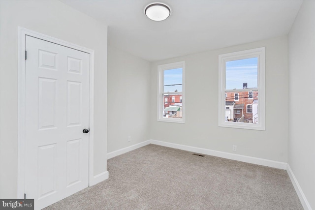 unfurnished room featuring light carpet