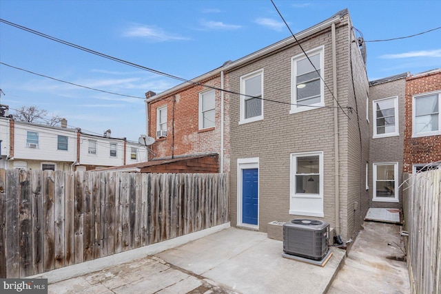 rear view of property featuring central AC unit and a patio area