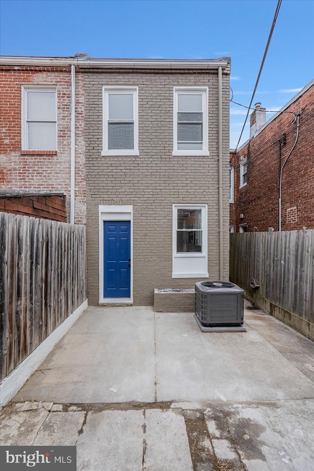 back of property with central AC unit and a patio area