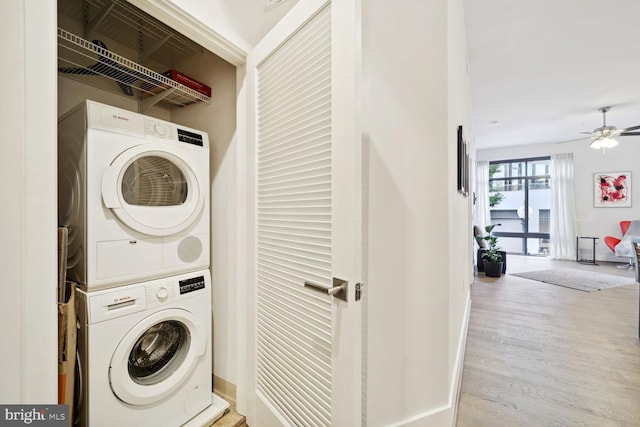 laundry room with ceiling fan, stacked washer and dryer, and light wood-type flooring