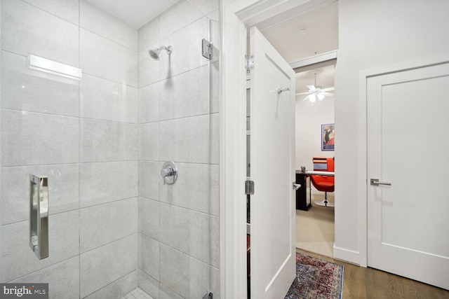 bathroom with wood-type flooring and tiled shower